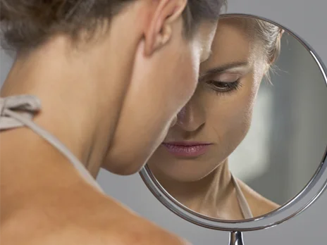 una persona che guarda uno specchio