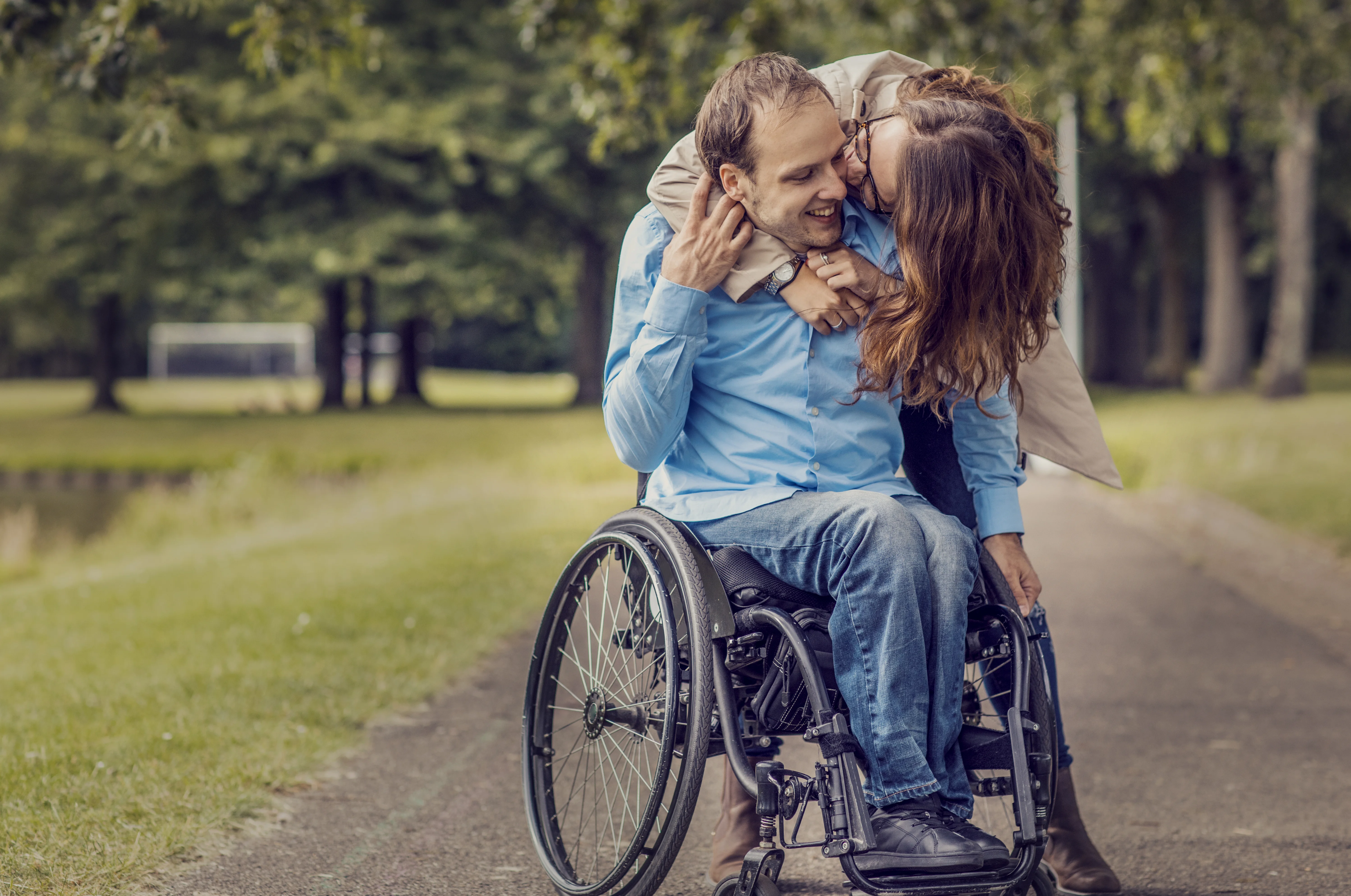 a man and woman kissing in a wheelchair