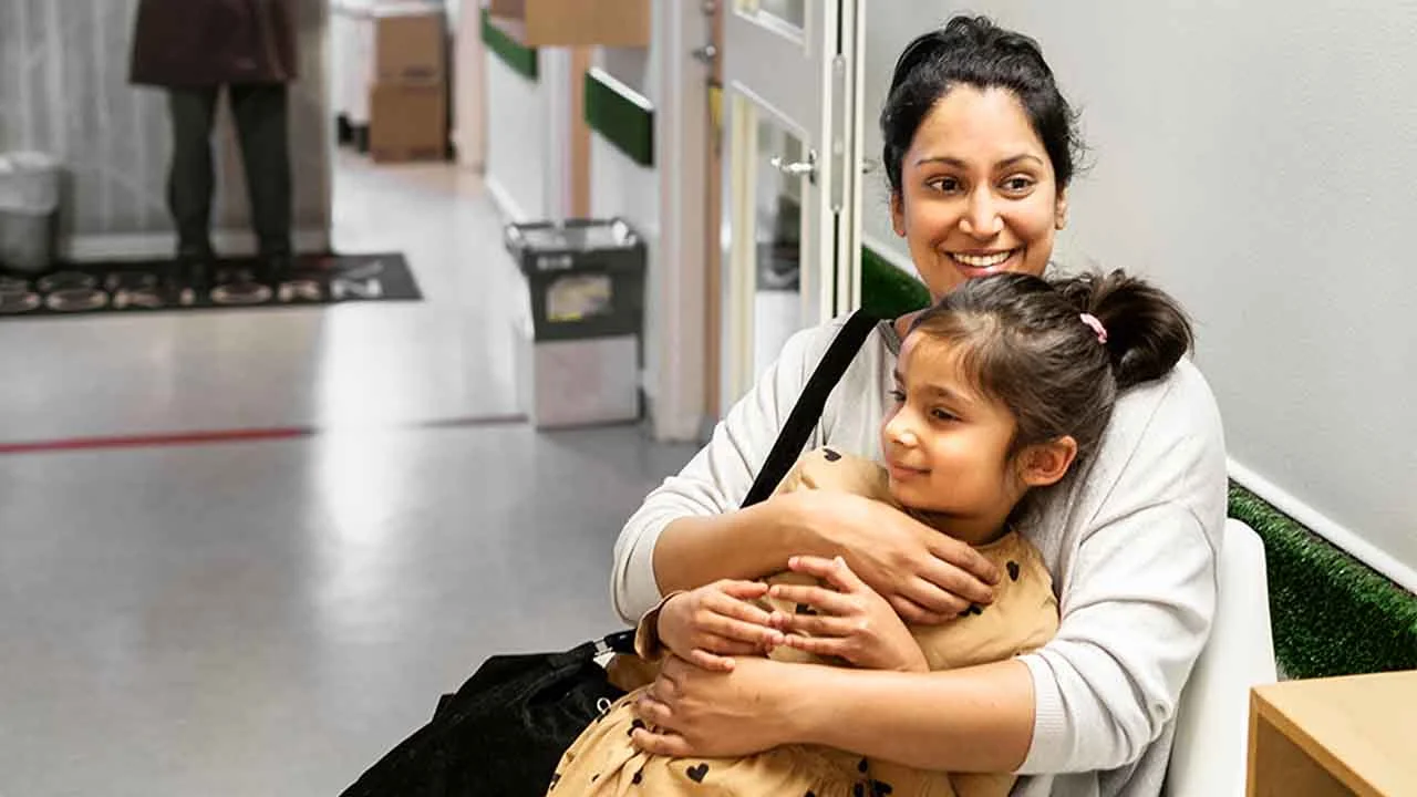 En person som håller ett barn i famnen